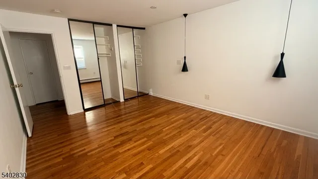 an empty room with wooden floor and entrance