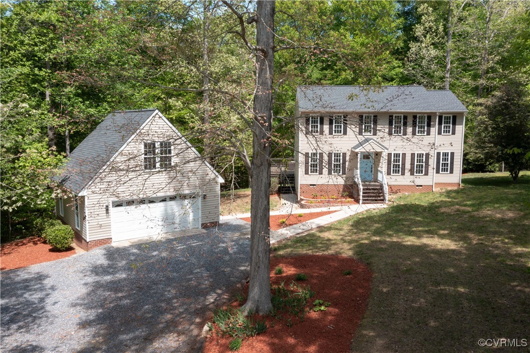 Colonial home featuring crawl space, a front lawn,