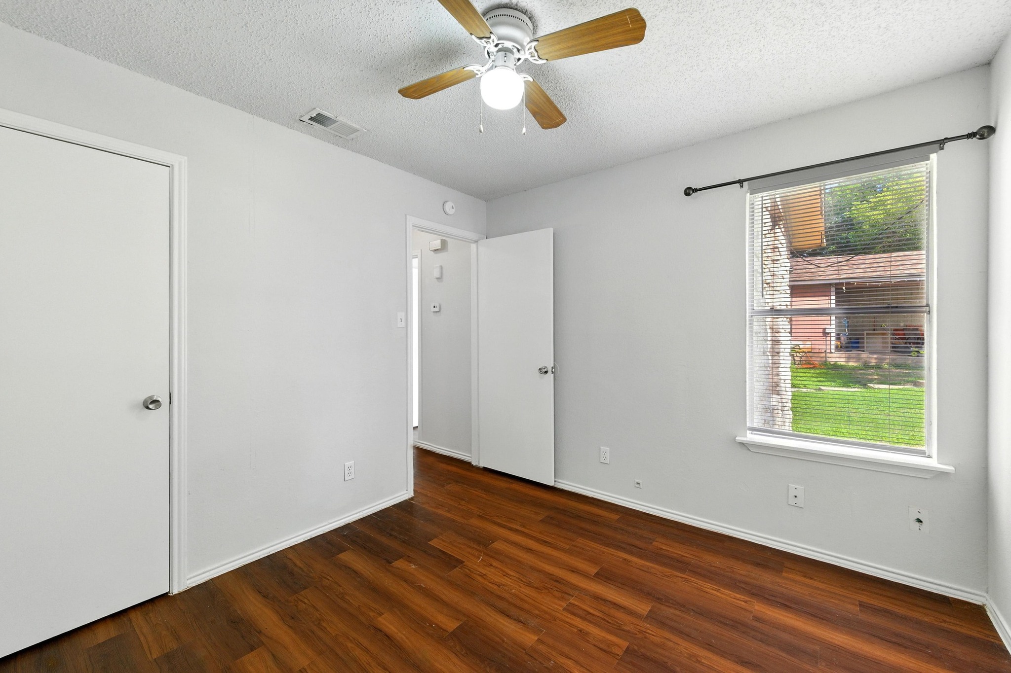 5707 Spring Meadow Road Austin, TX 78744 - Photo 18 of 21 a view of an empty room with window and wooden floor