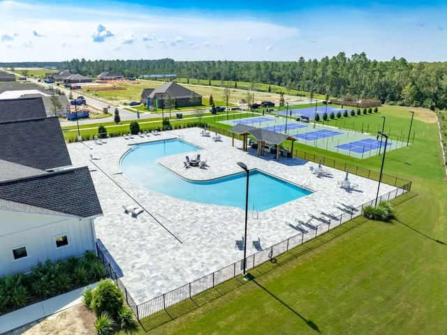 an aerial view of a house with a garden and lake view