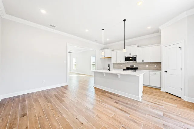 a view of kitchen with wooden floor window and stainless steel appliances