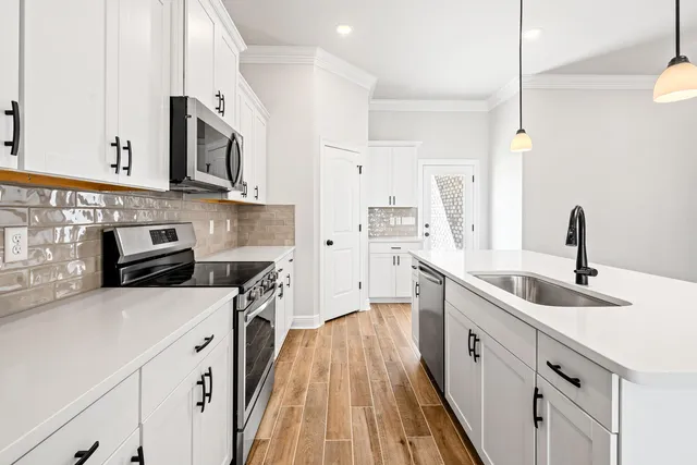 a kitchen with stainless steel appliances granite countertop a sink stove and refrigerator