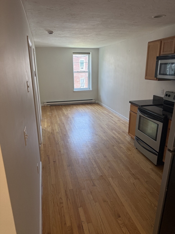 160 Cottage Street, Unit 2 Boston, MA 02128 - Photo 4 of 11 wooden floor in an empty room with a window