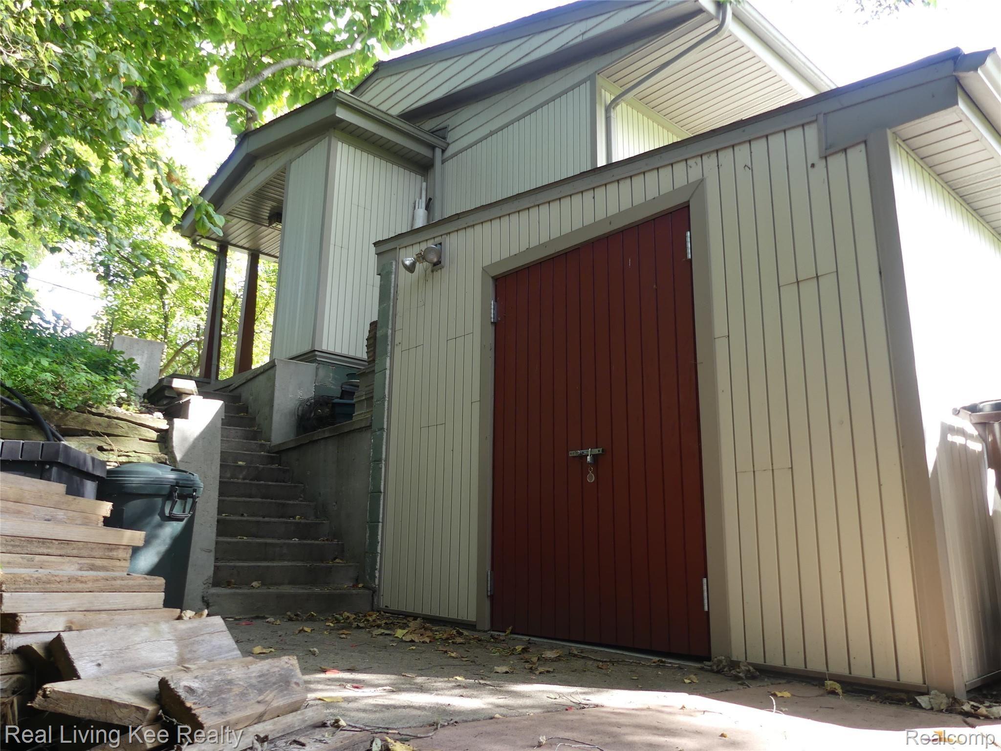 49741 Shelby Road Utica, MI 48317 - Photo 58 of 61 Outdoor shed is built into the north side of the house...steps lead to front porch.