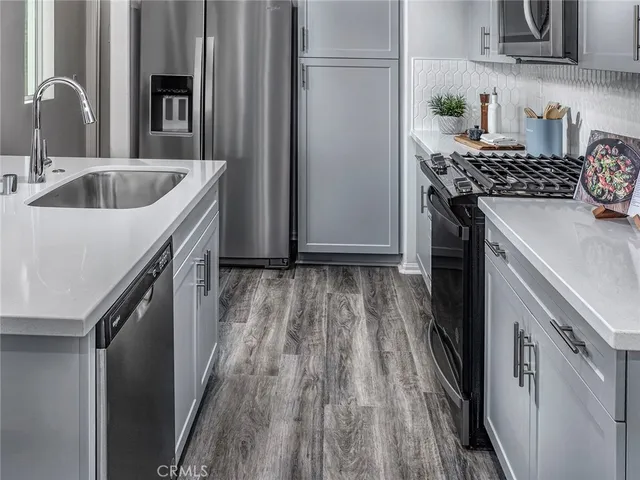 a kitchen with granite countertop a sink stove and refrigerator
