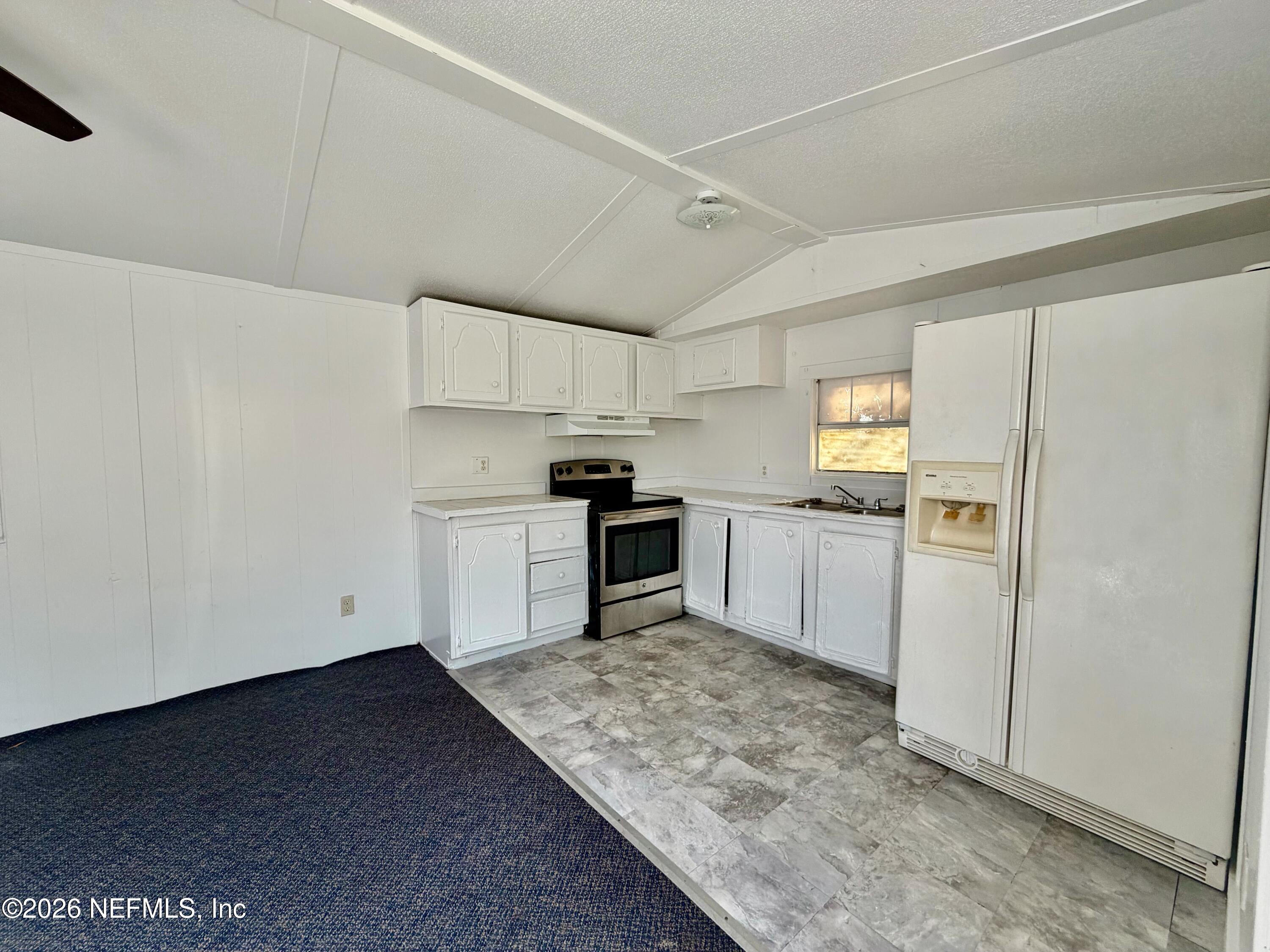 5355 New Kings Road, Unit 42 Jacksonville, FL 32209 - Photo 2 of 6 a kitchen with white cabinets and stainless steel appliances