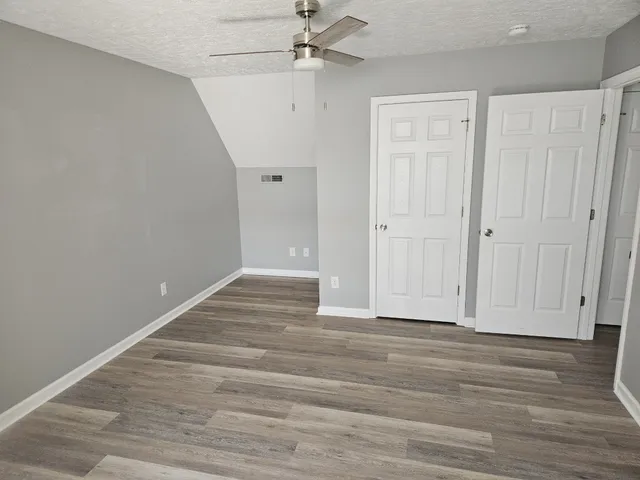 a view of an empty room with wooden floor