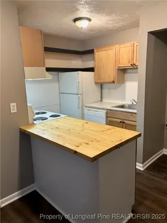 a kitchen with a sink a refrigerator and cabinets