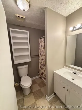 a bathroom with a toilet a sink and shower