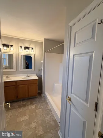 a large bathroom with a tub sink and mirror
