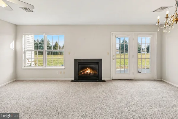 an empty room with windows and fireplace