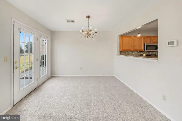 a view of a livingroom with a chandelier fan and windows