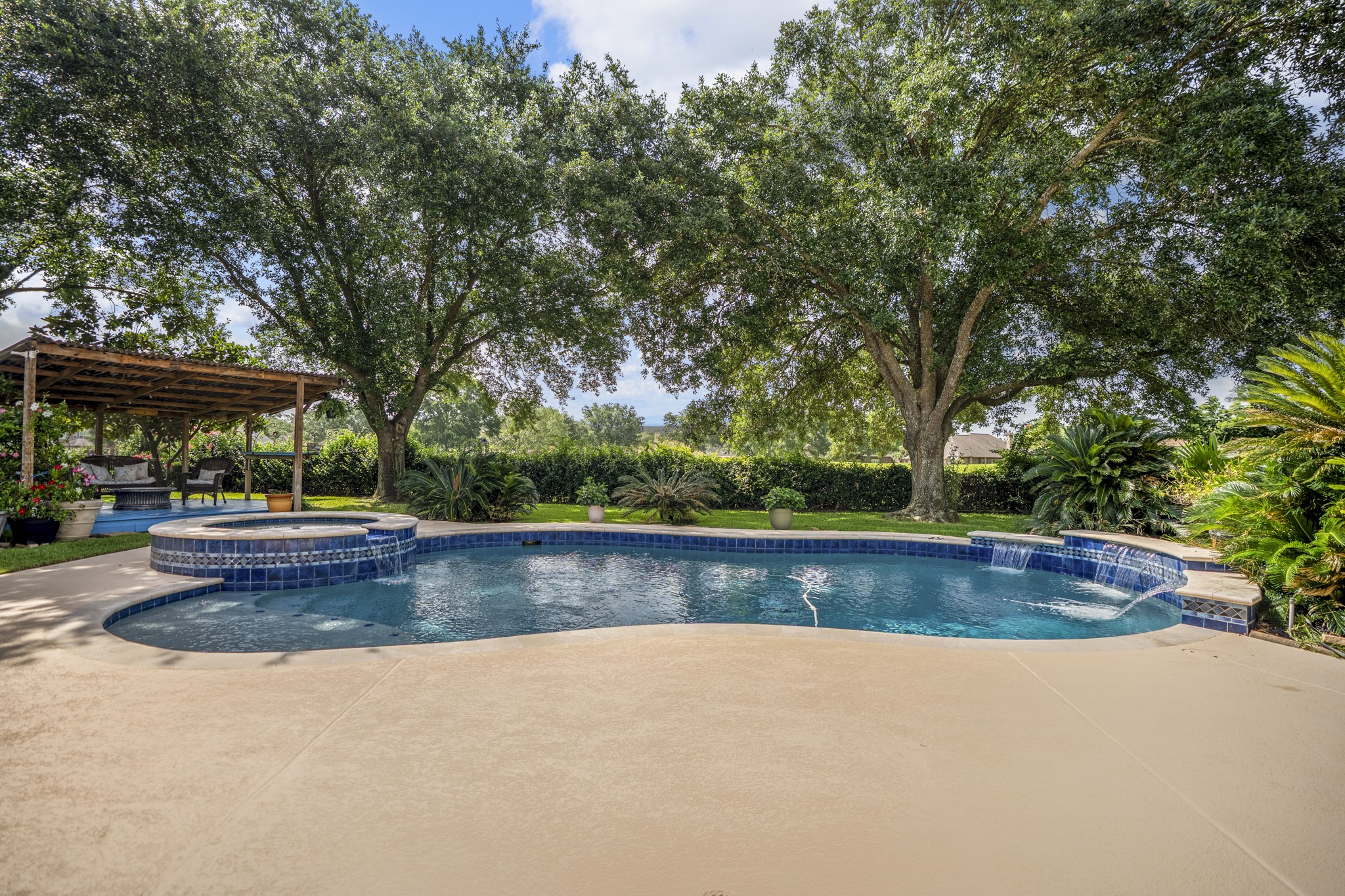 5807 Sequoia Trace Court Spring, TX 77379 - Photo 31 of 50 The backyard is where Windrose living really takes shape, with a pool, spa, waterfall feature, covered patio, and golf course views creating a true outdoor retreat just beyond the main living spaces.