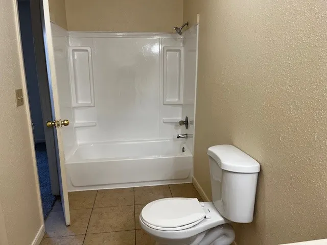 a white toilet sitting next to a bath tub