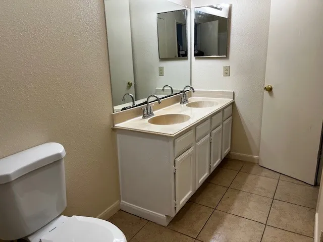 a bathroom with a sink a toilet and mirror
