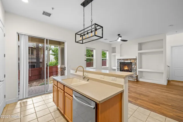a kitchen with stainless steel appliances granite countertop a sink a stove and a wooden floors