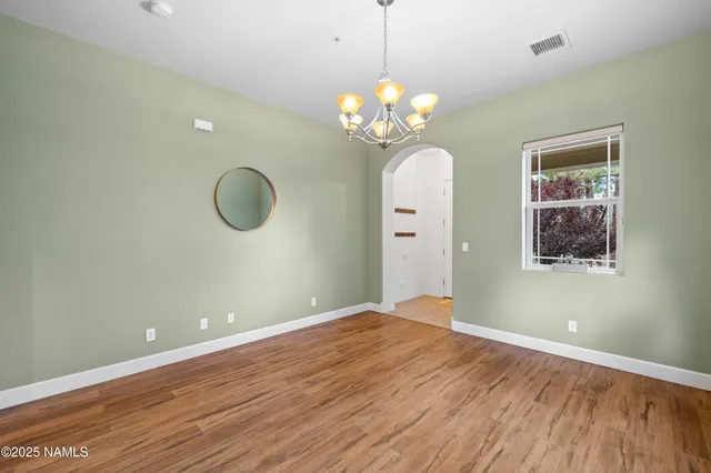 a view of room with wooden floor and chandelier