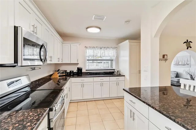a kitchen with white cabinets and sink