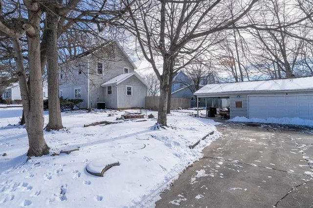 a front view of a house with a yard covered in snow