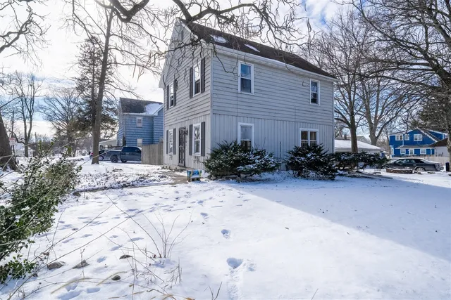 a view of a house with a yard covered in snow