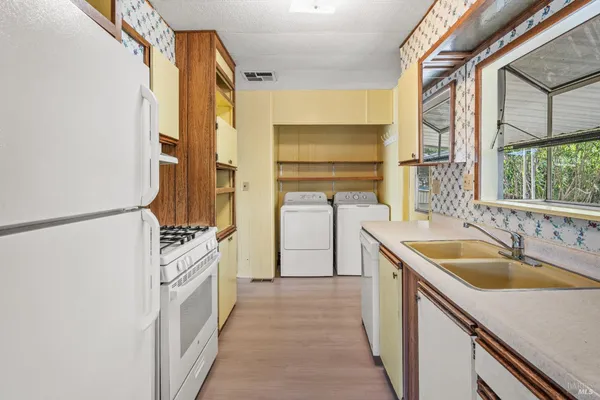 a kitchen with a sink stove top oven and refrigerator