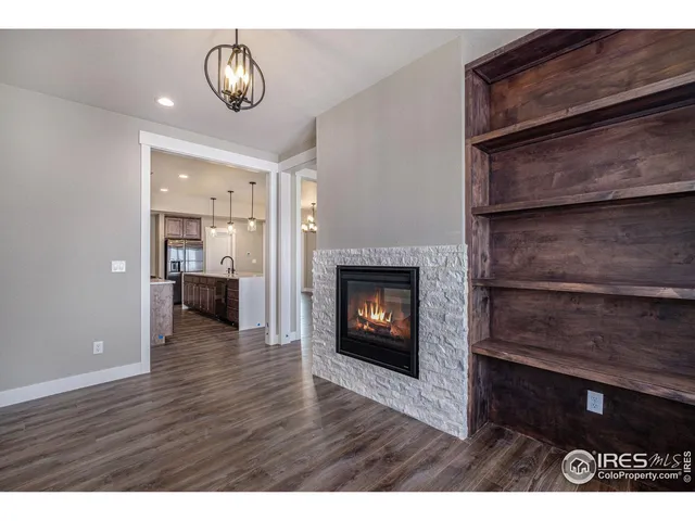 a kitchen with stainless steel appliances kitchen island granite countertop a refrigerator a sink dishwasher a stove and white cabinets with wooden floor