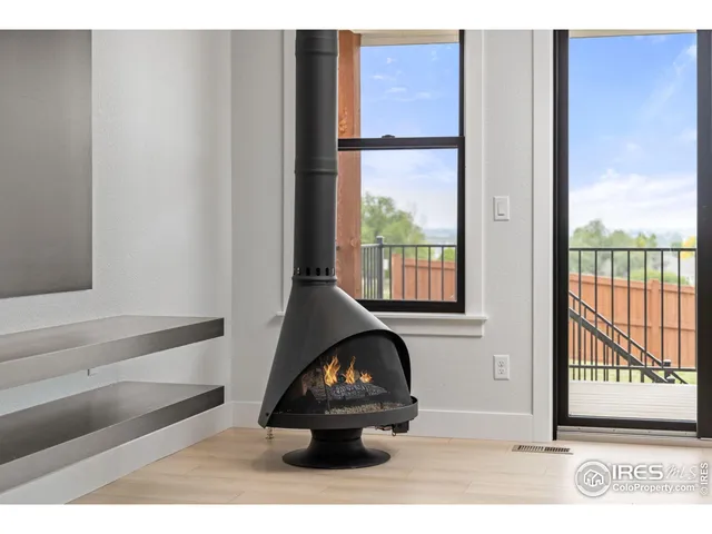 a living room with furniture a fireplace and a floor to ceiling window