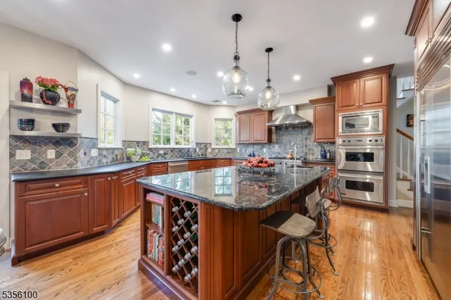a kitchen with stainless steel appliances granite countertop a sink refrigerator and cabinets