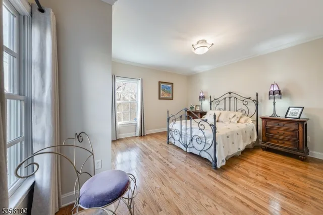 a bedroom with bed and wooden floor