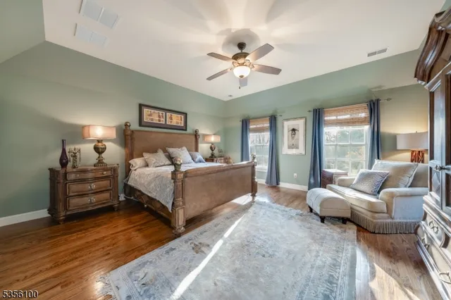 a spacious bedroom with a bed a couch and large windows