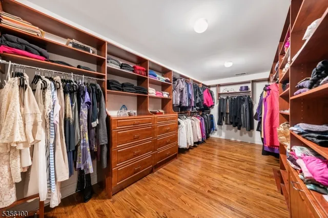 a view of walk in closet with clothes and shoes