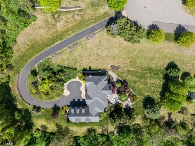 an aerial view of a house with a yard and lake view