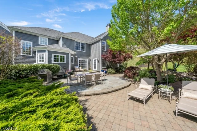 a view of a patio with couches table and chairs under an umbrella