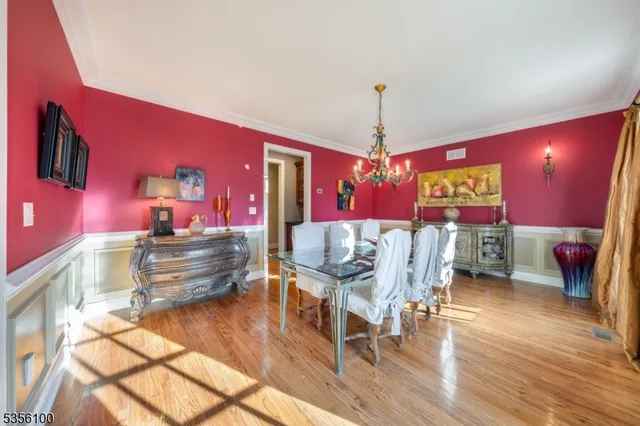 a dining room with furniture a chandelier and wooden floor