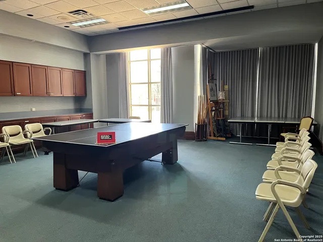 a room with pool table and windows