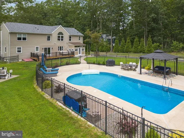 a view of backyard with swimming pool and seating space