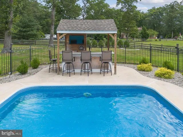 a view of a patio with a table and chairs under an umbrella with wooden fence