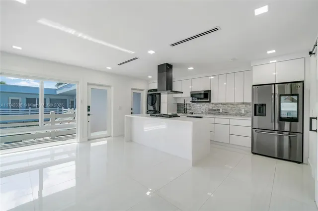 a kitchen with stainless steel appliances kitchen island a stove and a sink