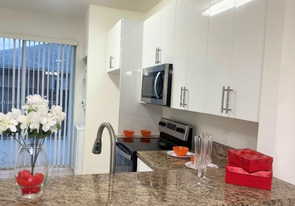 1548 Southwest 2nd Street Homestead, FL 33030 - Photo 6 of 15 a kitchen with stainless steel appliances granite countertop a sink and a wooden cabinets