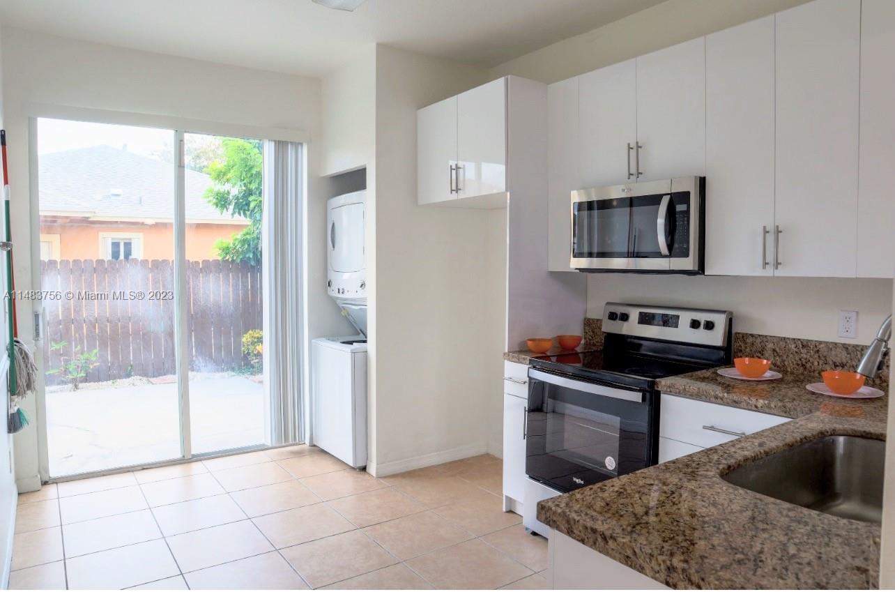 1548 Southwest 2nd Street Homestead, FL 33030 - Photo 8 of 15 a kitchen with stainless steel appliances granite countertop a stove a sink and a microwave