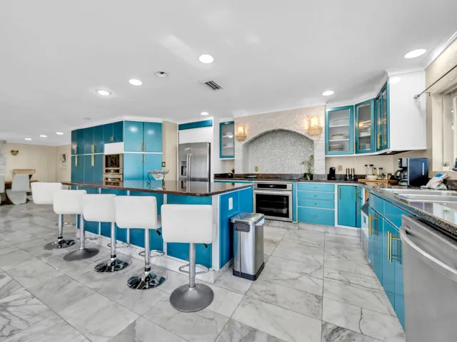 a kitchen with stainless steel appliances granite countertop a sink a stove and a microwave