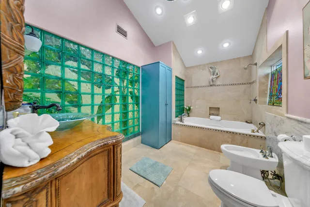 a kitchen with stainless steel appliances granite countertop a refrigerator a sink dishwasher a dining table and chairs with wooden floor