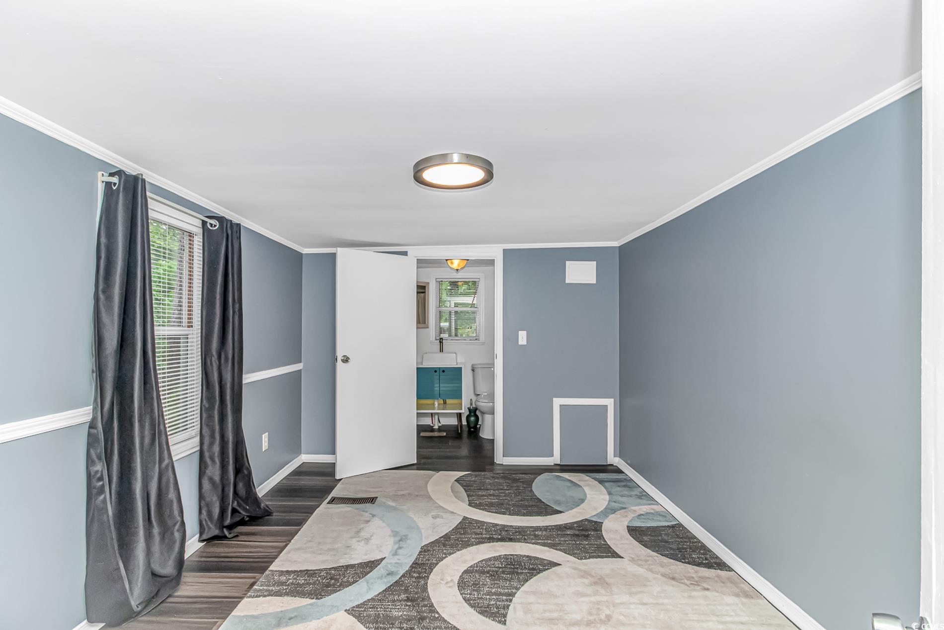 159 Offshore Drive Murrells Inlet, SC 29576 - Photo 13 of 35 Empty room with inlaid floor details, dark wood-type flooring, baseboards, and crown molding