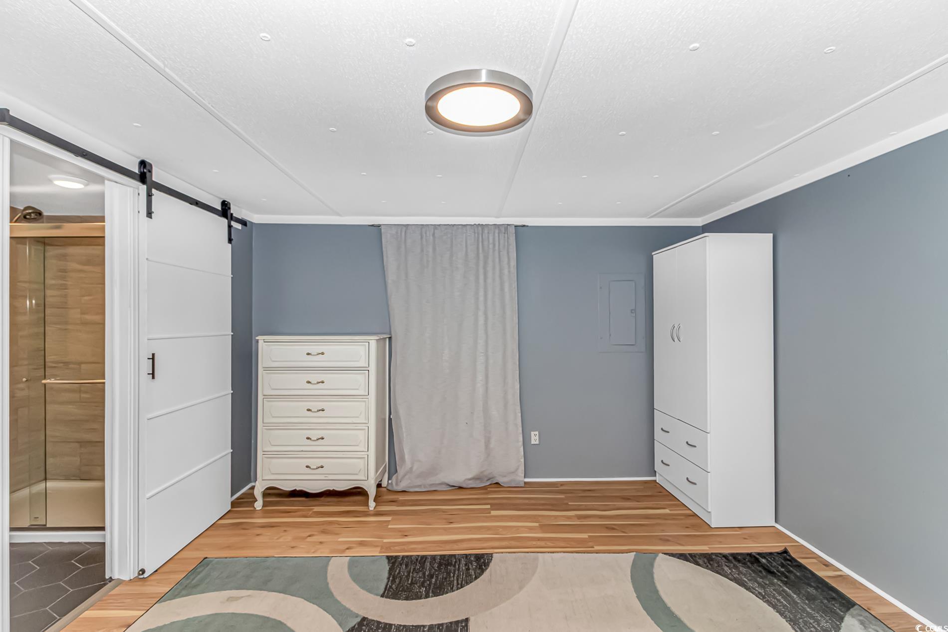 159 Offshore Drive Murrells Inlet, SC 29576 - Photo 18 of 35 Bedroom featuring light wood finished floors, a barn door, and ensuite bath