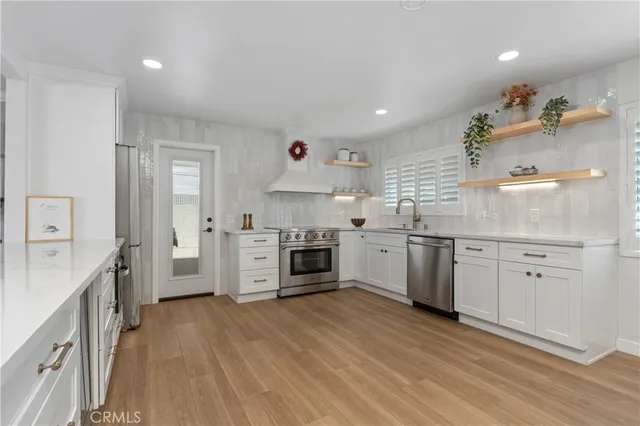 a kitchen with granite countertop a sink cabinets and stainless steel appliances