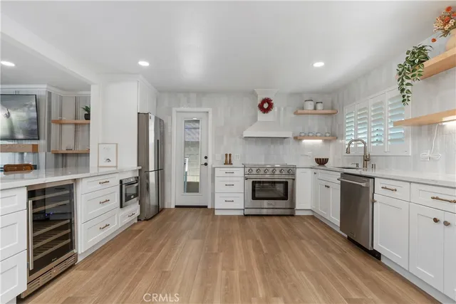 a kitchen with white cabinets stainless steel appliances and a window