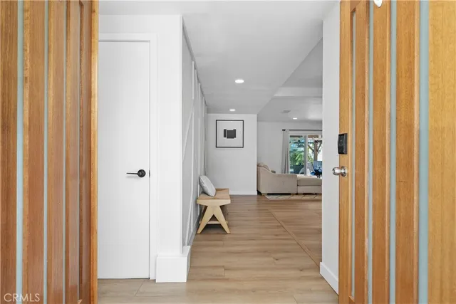 a view of a hallway with wooden floor windows and a livingroom