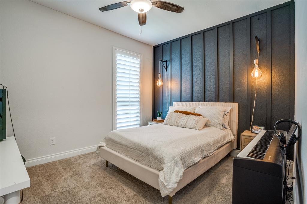 880 Manchester Avenue Prosper, TX 75078 - Photo 14 of 26 a bedroom with a bed and a chandelier