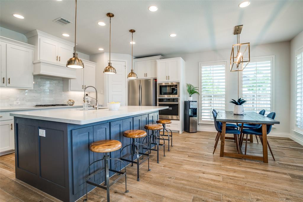 880 Manchester Avenue Prosper, TX 75078 - Photo 6 of 26 a dining table with chairs and kitchen view