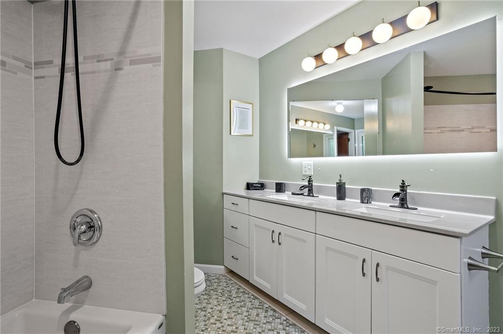 25 Coachman Pike Ledyard, CT 06339 - Photo 21 of 37 a bathroom with a granite countertop sink a toilet a mirror and shower